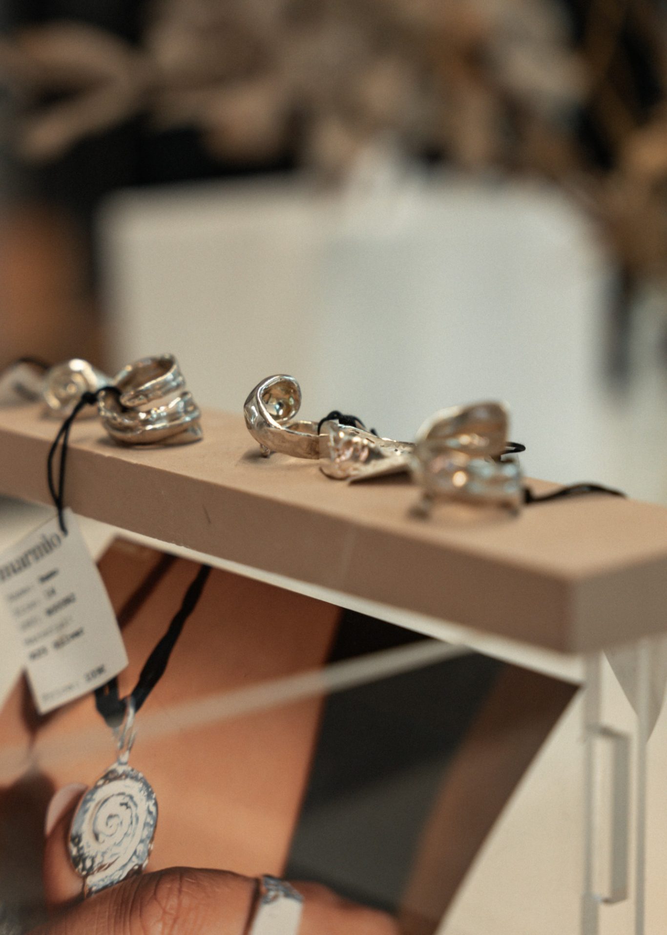 Mehrere silberne Ringe auf einem Ausstellungstisch, dazu ein Preisetikett.