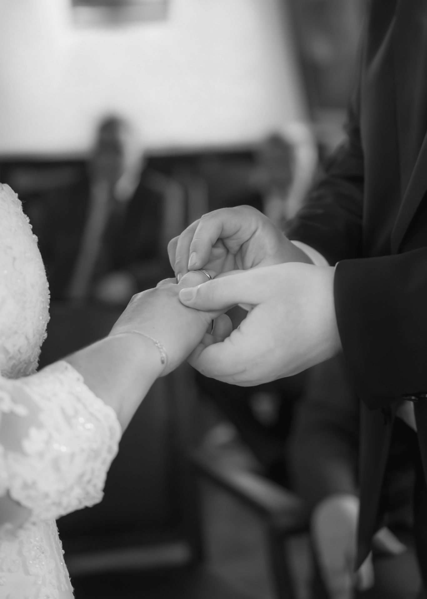 Hände eines Paares beim Austausch von Ringen während einer Trauzeremonie.